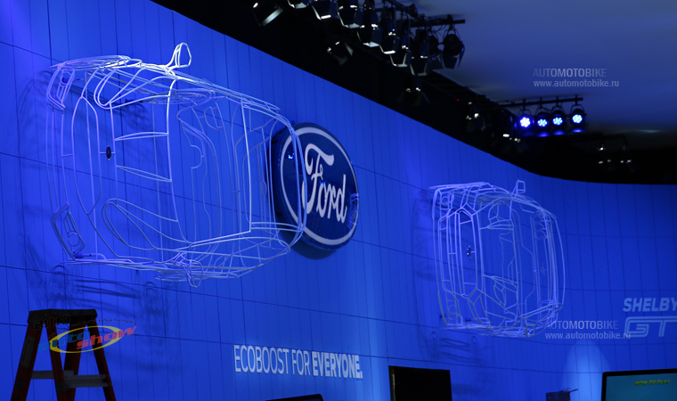 Стенд компании Ford автомобили в воздухе на автосалоне в Нью Йорке 2015 Стенд компании Ford автомобили в воздухе на автосалоне в Нью Йорке 2015